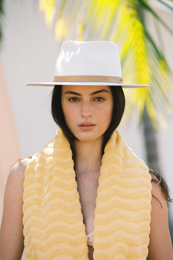 Model wearing a white Diego Wool Felt Fedora Hat with a yellow towel around her neck