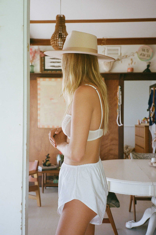 Model wearing an Ivory Rancher wool felt fedora hat in a room setting