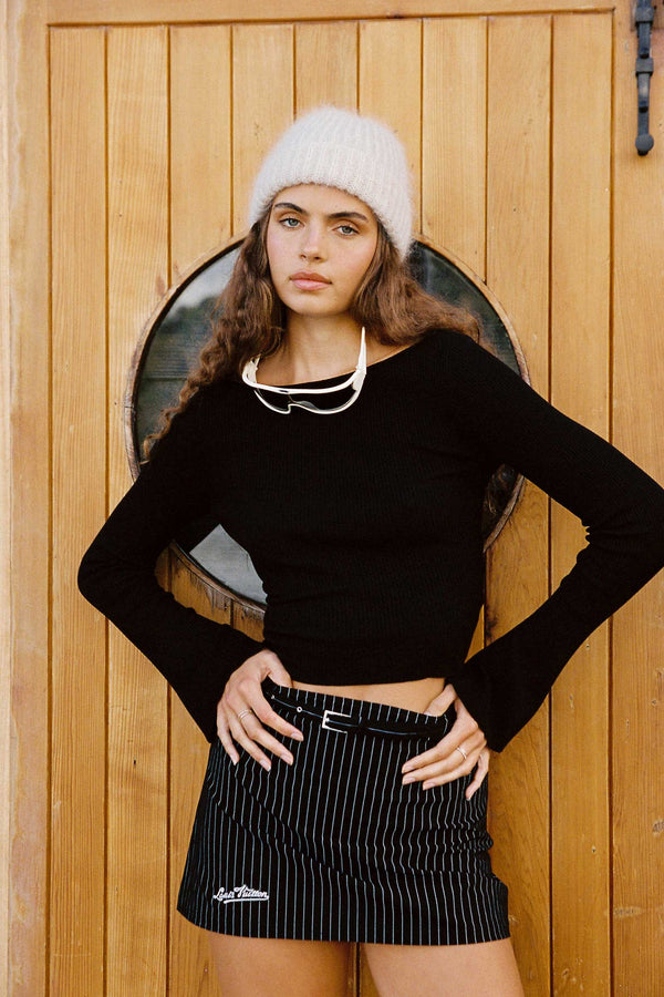 Model wearing Mason Beanie in Natural, styled with a black top and striped skirt.