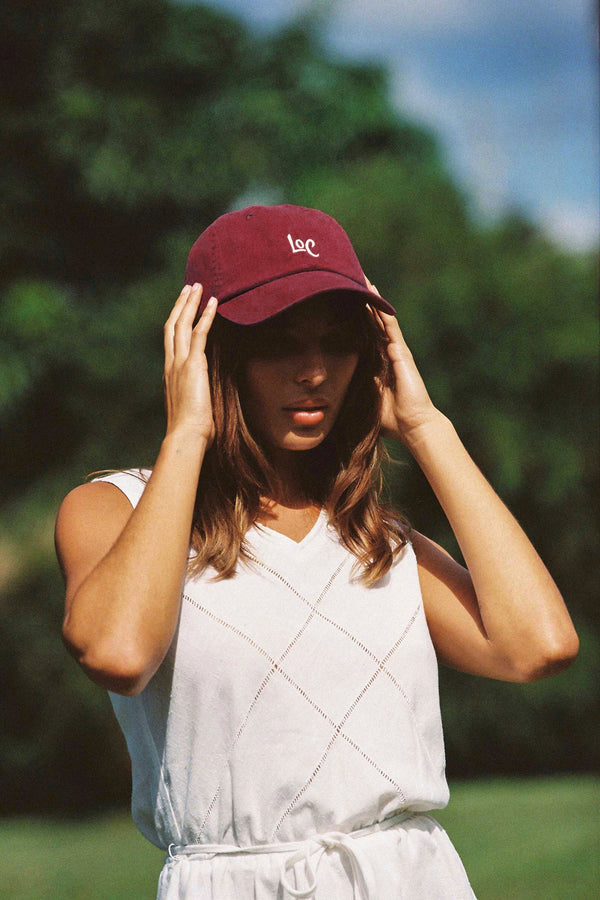Model wearing a maroon LOC cap outdoors, with 'LOC' logo visible on the front.
