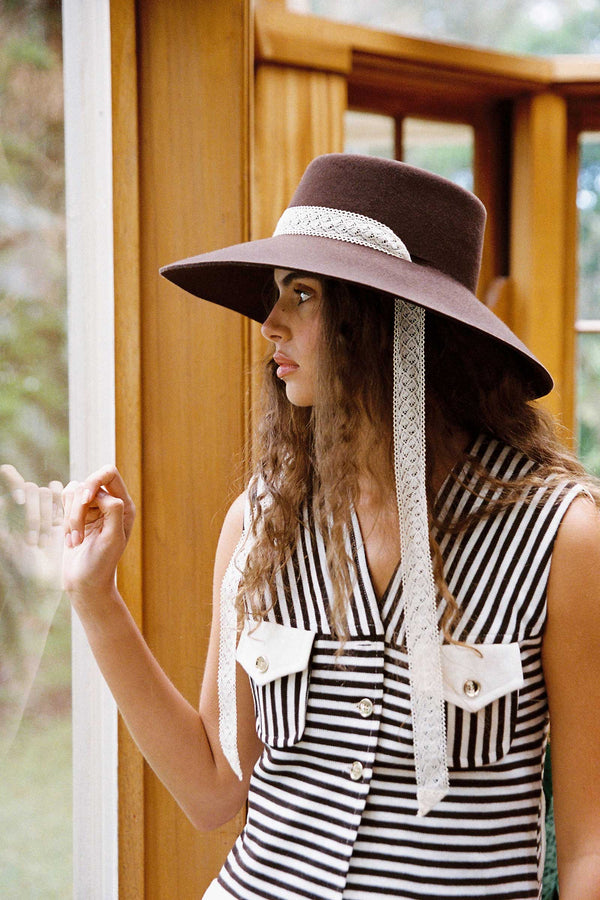 Model wearing the Paloma Midi Wool Felt Boater Hat in Brown with lace ribbons