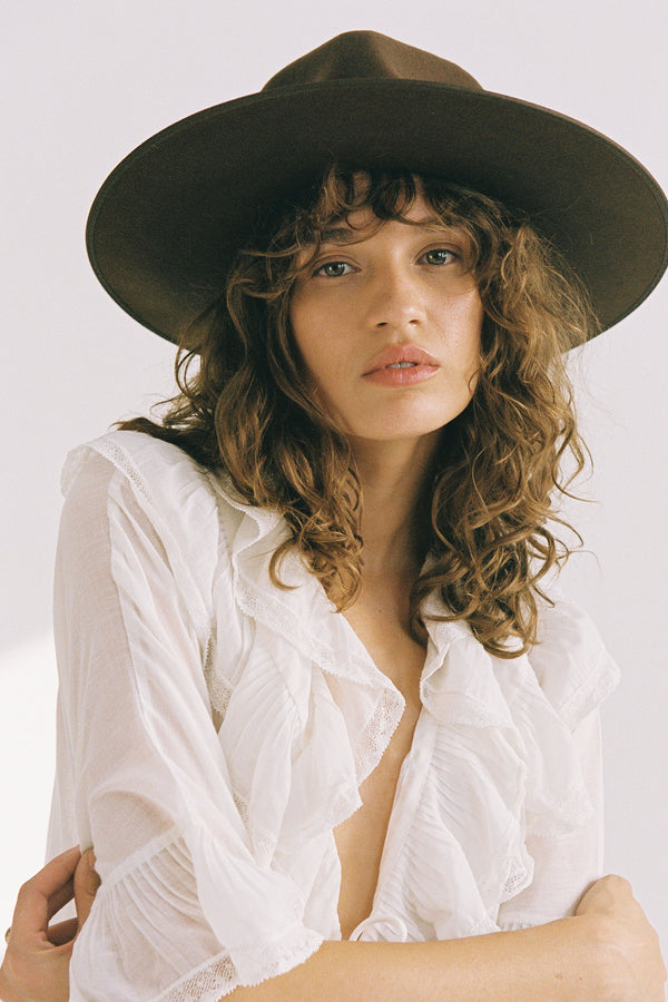 Model wearing an Espresso Rancher wool felt hat in brown, featuring a wide brim and a structured design.