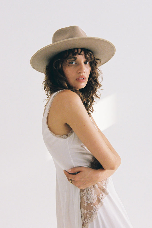 Model wearing a Fawn Rancher wool felt hat in brown, styled with a white dress.