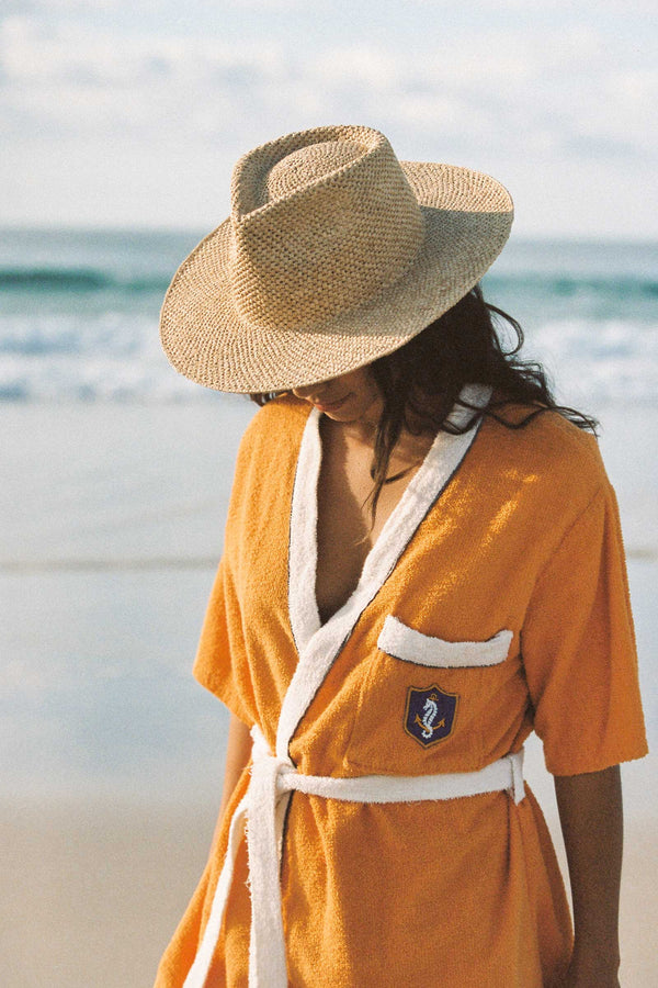 Model wearing The Inca Fedora on the beach, with ocean in the background.