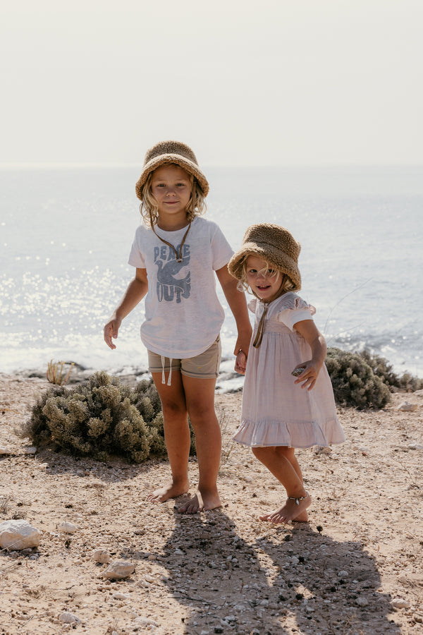 Two children wearing brown Teddy Bucket hats on a beach.