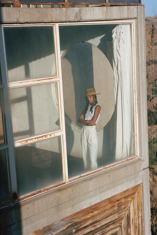 Model wearing The Mirage brown wool felt fedora hat in a modern architectural setting
