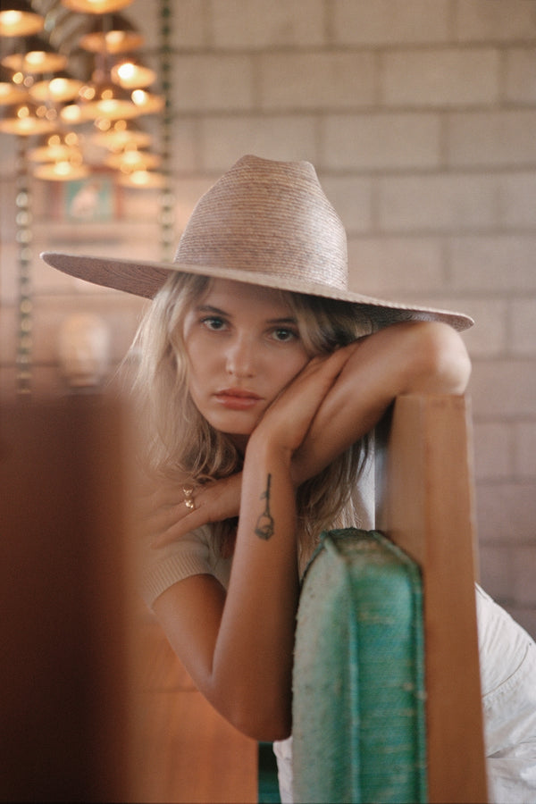 Model wearing the Western Wide Palma straw cowboy hat, showcasing its design and style.
