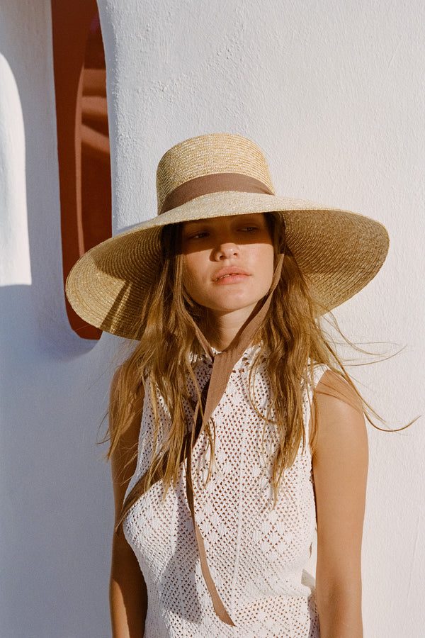 Paloma Sun Hat made from natural straw with a wide brim and chocolate brown neck tie, ideal for sun protection.