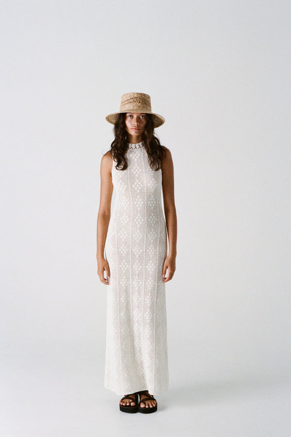Model wearing Inca Bucket Wide straw hat, standing in a light-colored dress against a plain background.