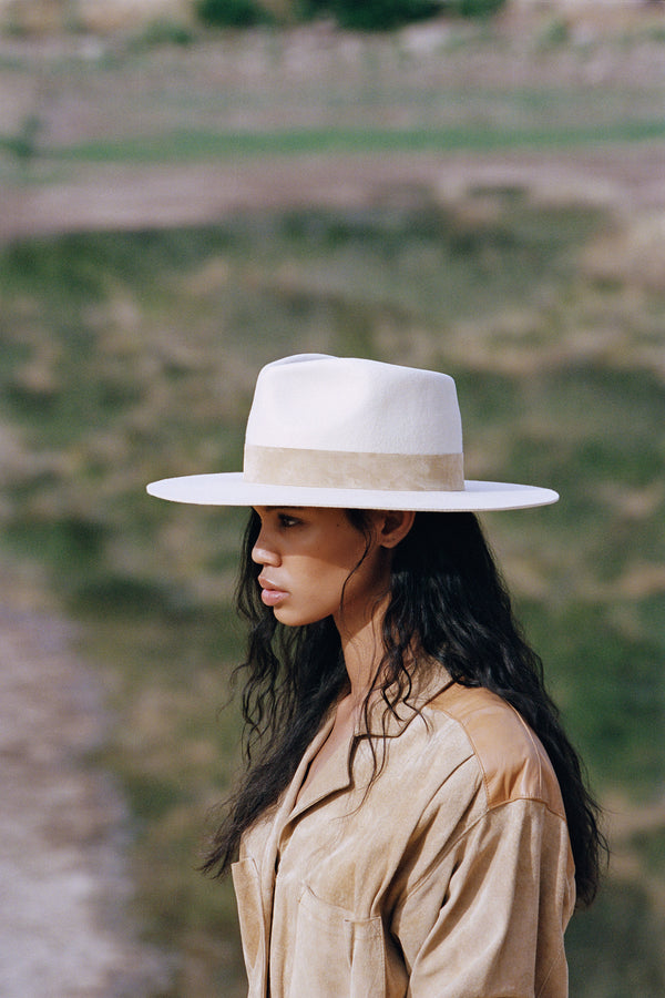 Model wearing The Mirage ivory wool felt fedora hat outdoors